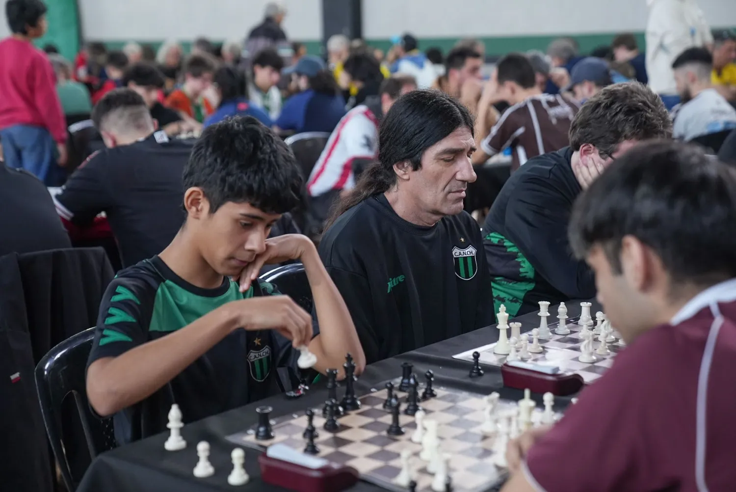 Jugadores de Nueva Chicago concentrados sobre el tablero durante un torneo de ajedrez